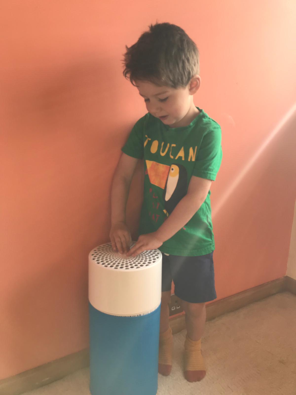 blue air purifier review little boy pressing on button