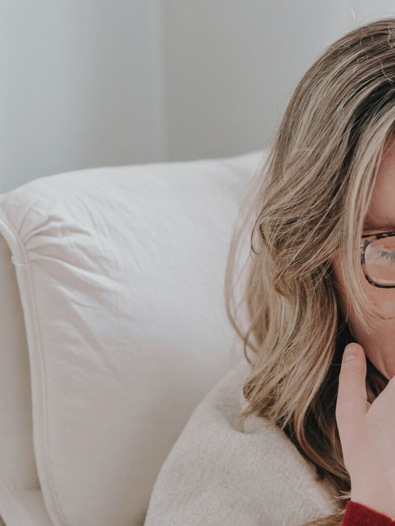 A tired woman yawning, struggling with low energy and exhaustion – how to fix low energy naturally.