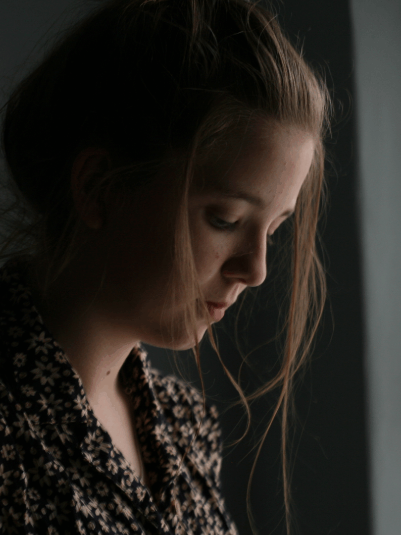 A visibly exhausted woman sitting alone, reflecting the emotional and physical weight of postpartum depletion.