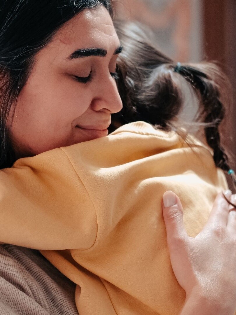 Mother holding child in a quiet moment, showing signs of emotional overwhelm and silent struggle with postpartum rage.